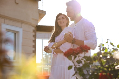 Lovely young couple dancing together outdoors on sunny day