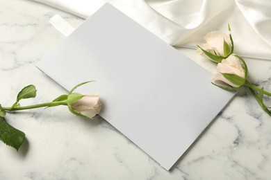 Photo of Scented sachet, roses and fabric on white marble table