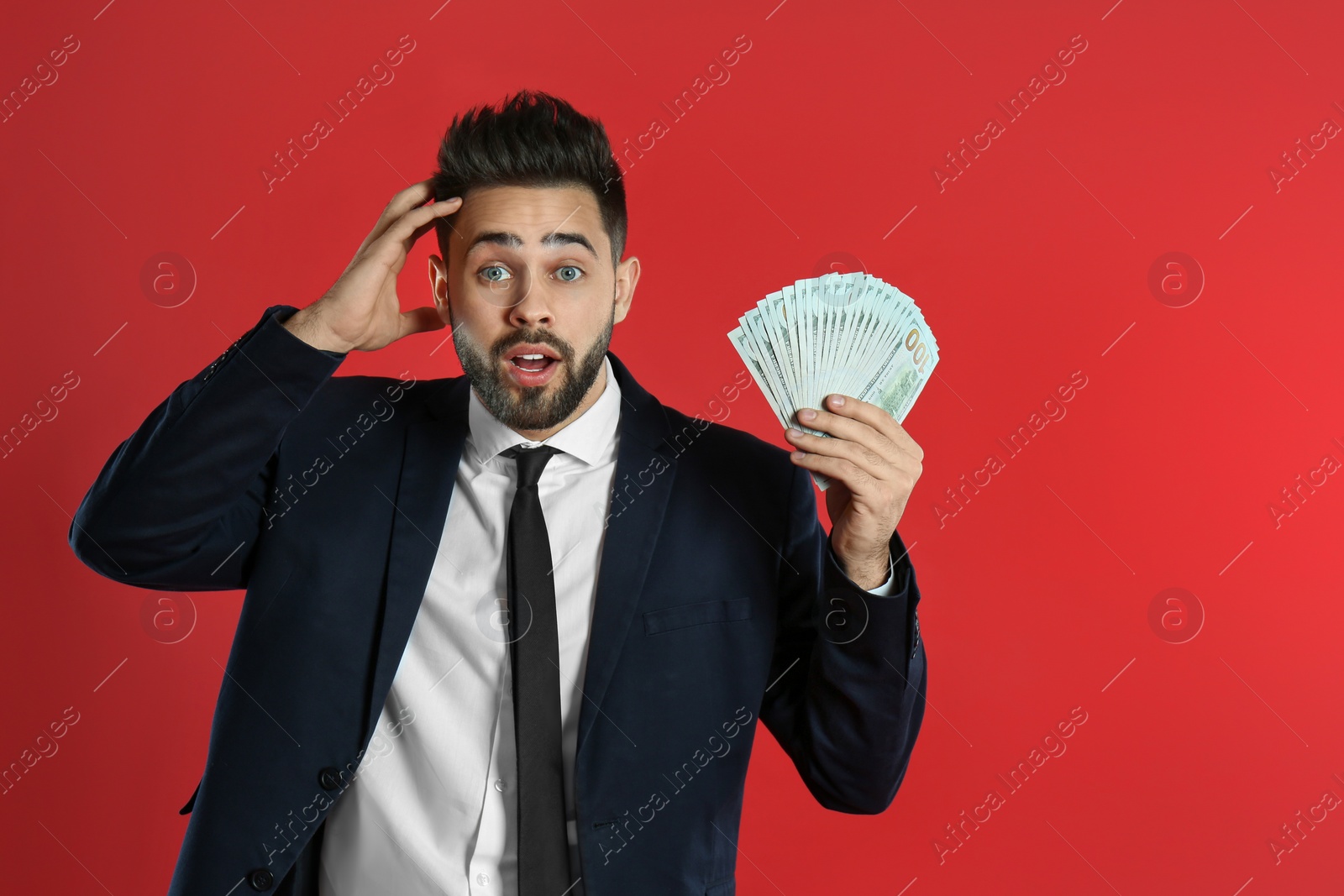 Photo of Emotional young man with money on crimson background