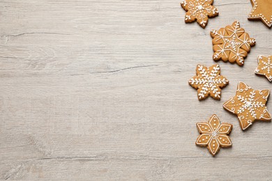 Tasty Christmas cookies on beige wooden table, flat lay. Space for text