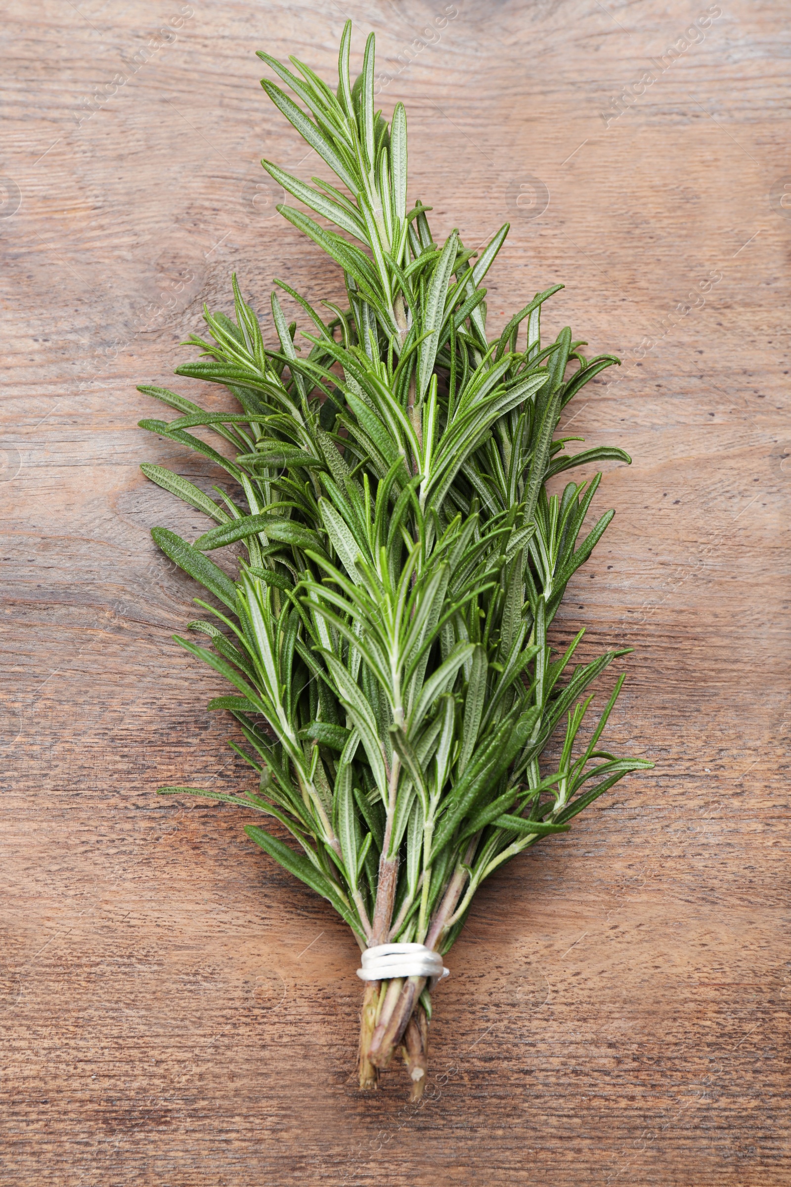 Photo of Bunch of fresh rosemary on wooden table, top view