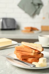 Photo of Tasty toasts with butter served on grey marble table