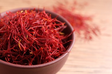 Photo of Dried saffron in bowl on table, closeup