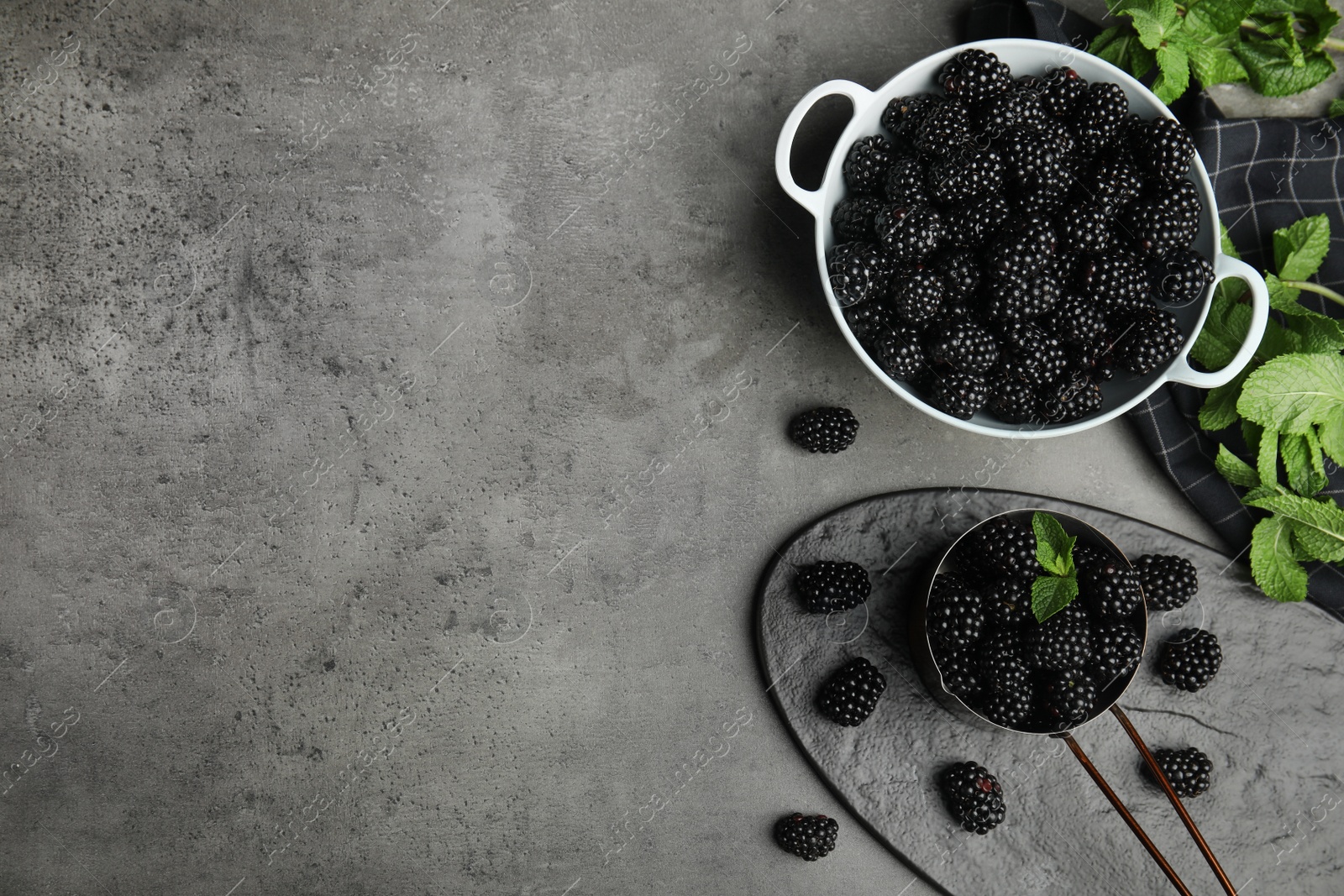 Photo of Flat lay composition of tasty blackberries and space for text on grey table