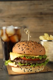 Photo of Burger with delicious patty, soda drink and french fries on gray table