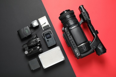 Photo of Flat lay composition with camera and video production equipment on color background