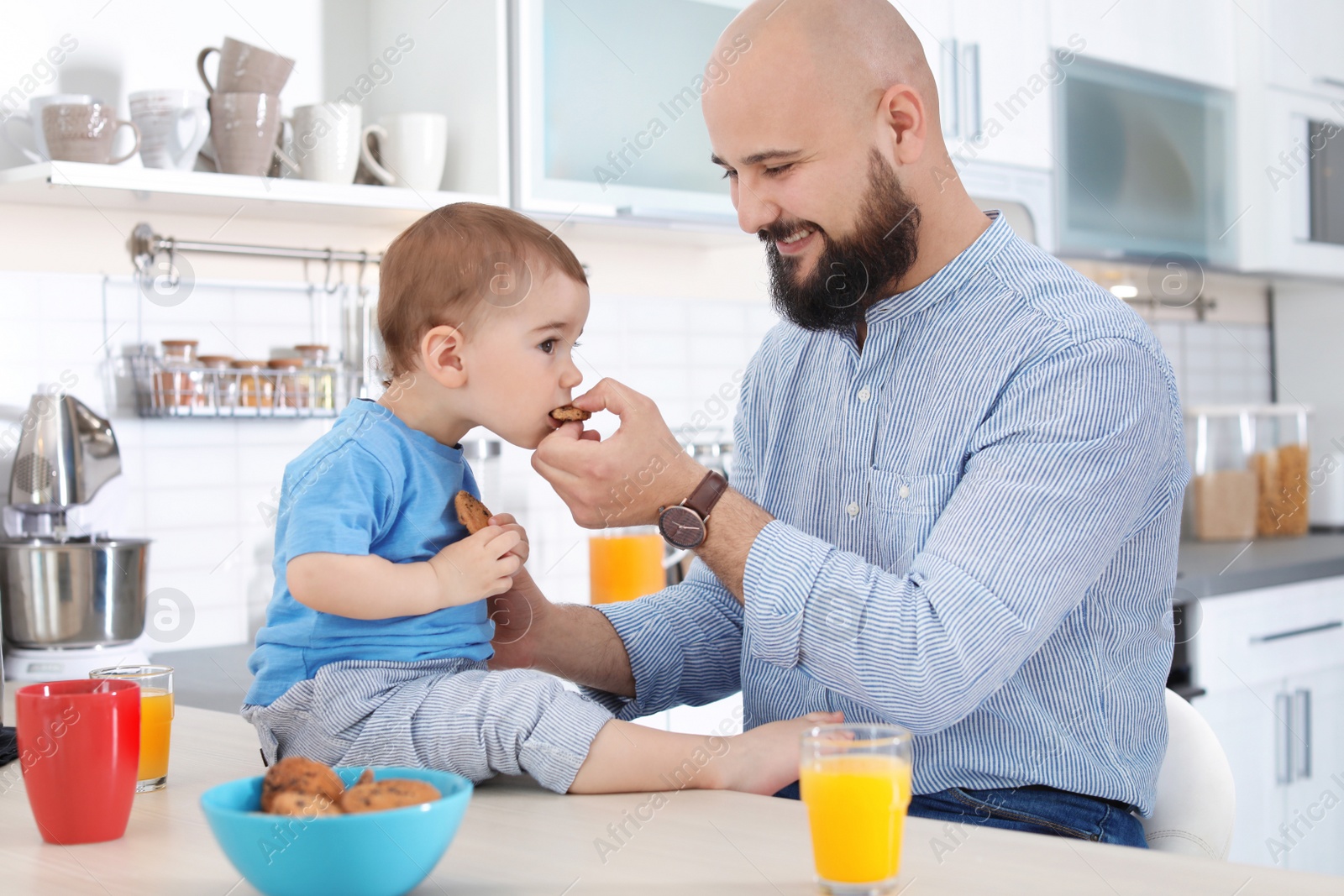 Photo of Dad having breakfast with little son in kitchen