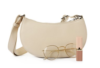 Photo of Stylish baguette bag with glasses and lipstick on white background