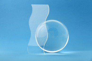 Photo of Composition with transparent glass ball on blue background