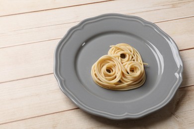 Photo of Heart made of tasty spaghetti on wooden table