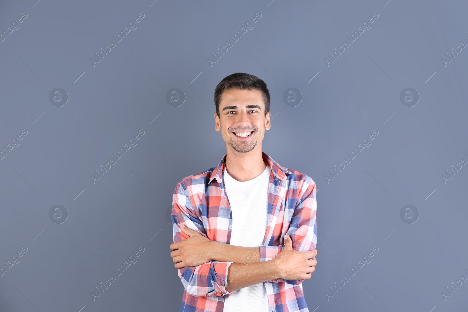 Photo of Portrait of handsome young man smiling on color background