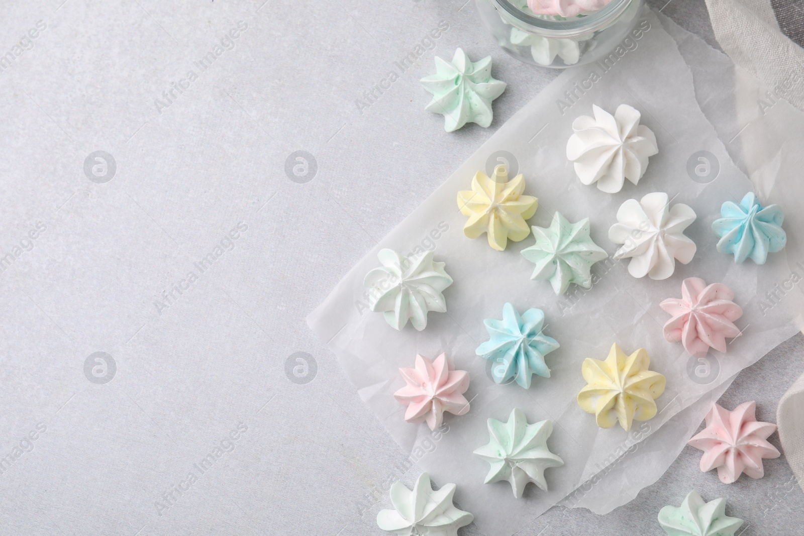 Photo of Tasty meringue cookies on light grey table, flat lay. Space for text