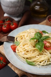 Photo of Delicious pasta with brie cheese, tomatoes and basil leaves on table, closeup