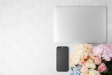 Flat lay composition with beautiful hydrangea and rose flowers on white tiled table, space for text