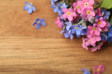 Photo of Beautiful fresh Forget-me-not flowers on wooden table, top view. Space for text