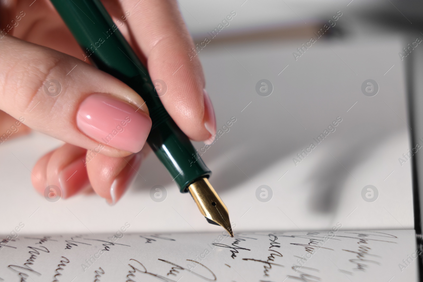 Photo of Woman writing with fountain pen in notebook, closeup. Space for text