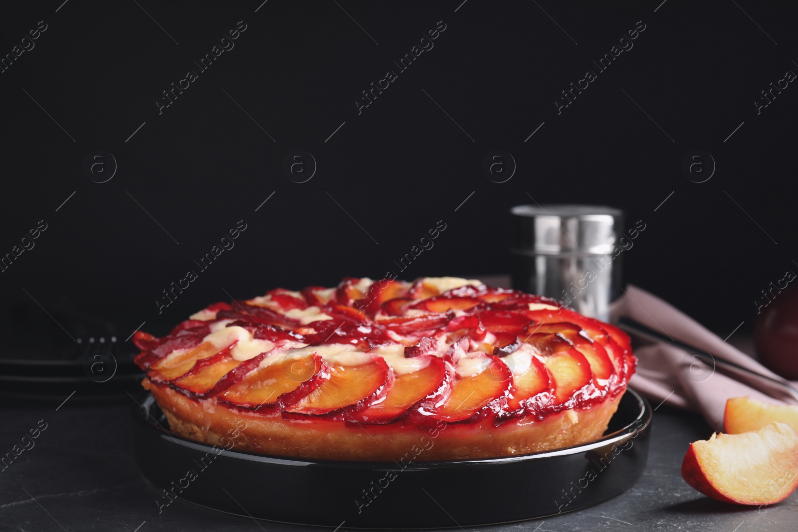 Photo of Delicious cake with plums on grey table
