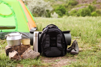 Photo of Backpack and set of dishware for camping outdoors