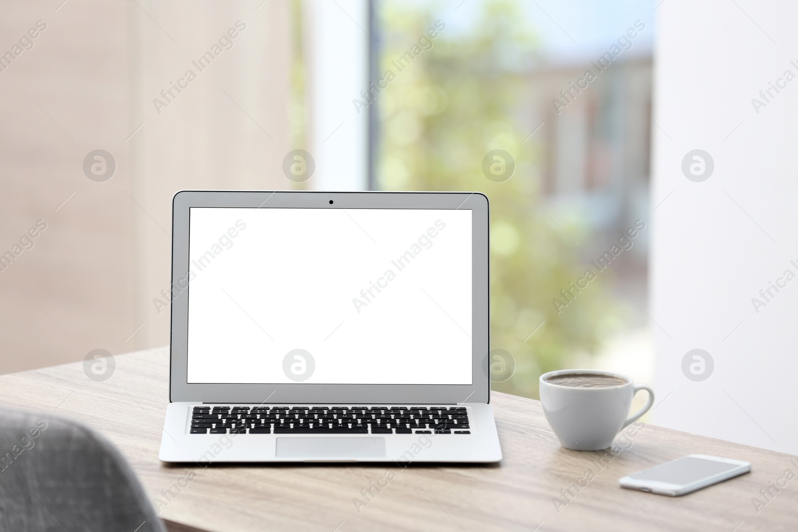 Photo of Modern laptop on desk in room. Home workplace