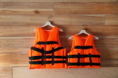 Orange life jackets on wooden background. Personal flotation device