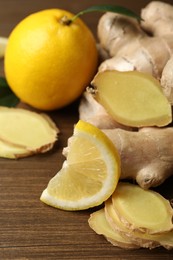 Photo of Fresh lemons and ginger on wooden table, closeup