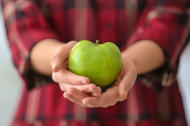 Photo of Woman holding ripe green apple, closeup