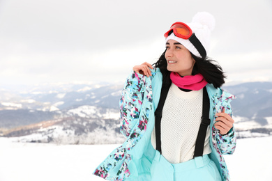Portrait of beautiful woman on snowy hill. Winter vacation