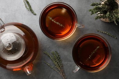 Aromatic herbal tea with thyme on grey table, flat lay