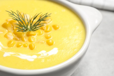 Photo of Delicious creamy corn soup in bowl on table, closeup