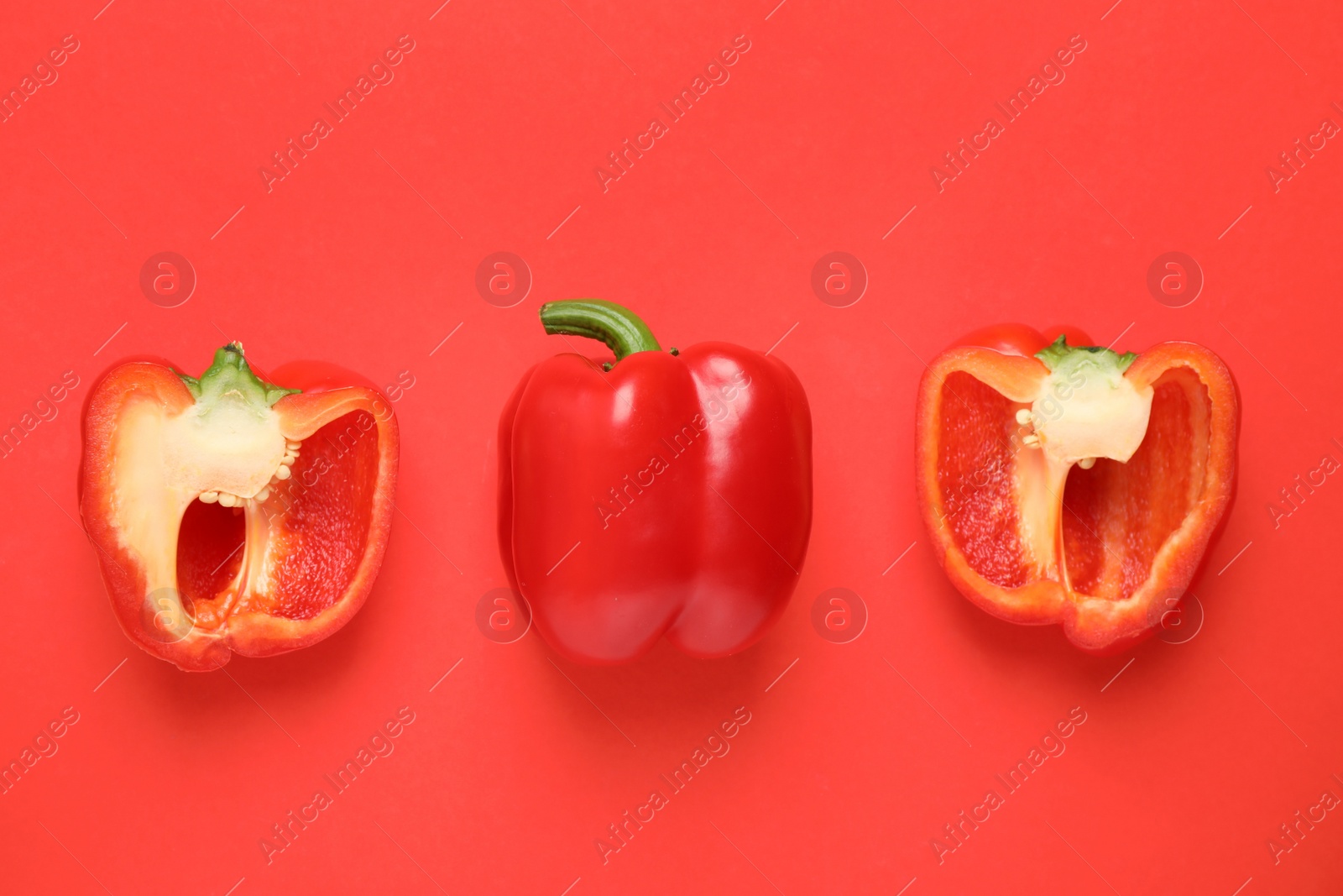 Photo of Delicious cut bell peppers on red background, flat lay