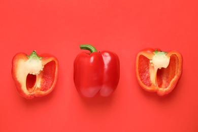 Delicious cut bell peppers on red background, flat lay