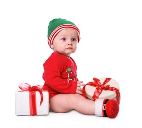 Photo of Cute little baby wearing Santa's elf clothes with Christmas gifts on white background