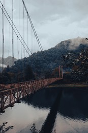 Image of Beautiful view on rusty metal bridge over river in mountains