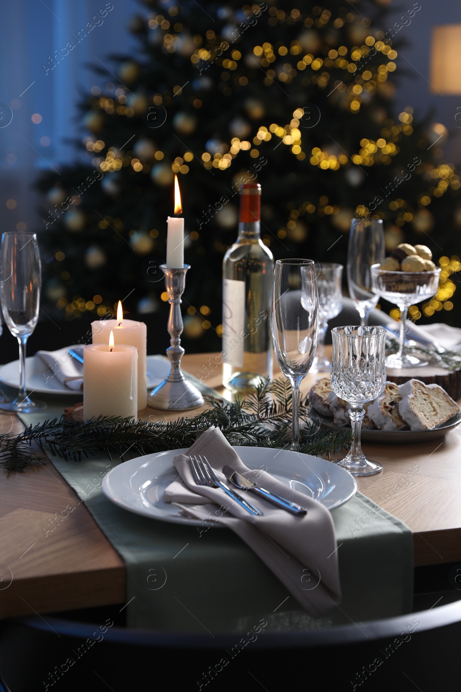 Photo of Christmas table setting with festive decor and dishware indoors