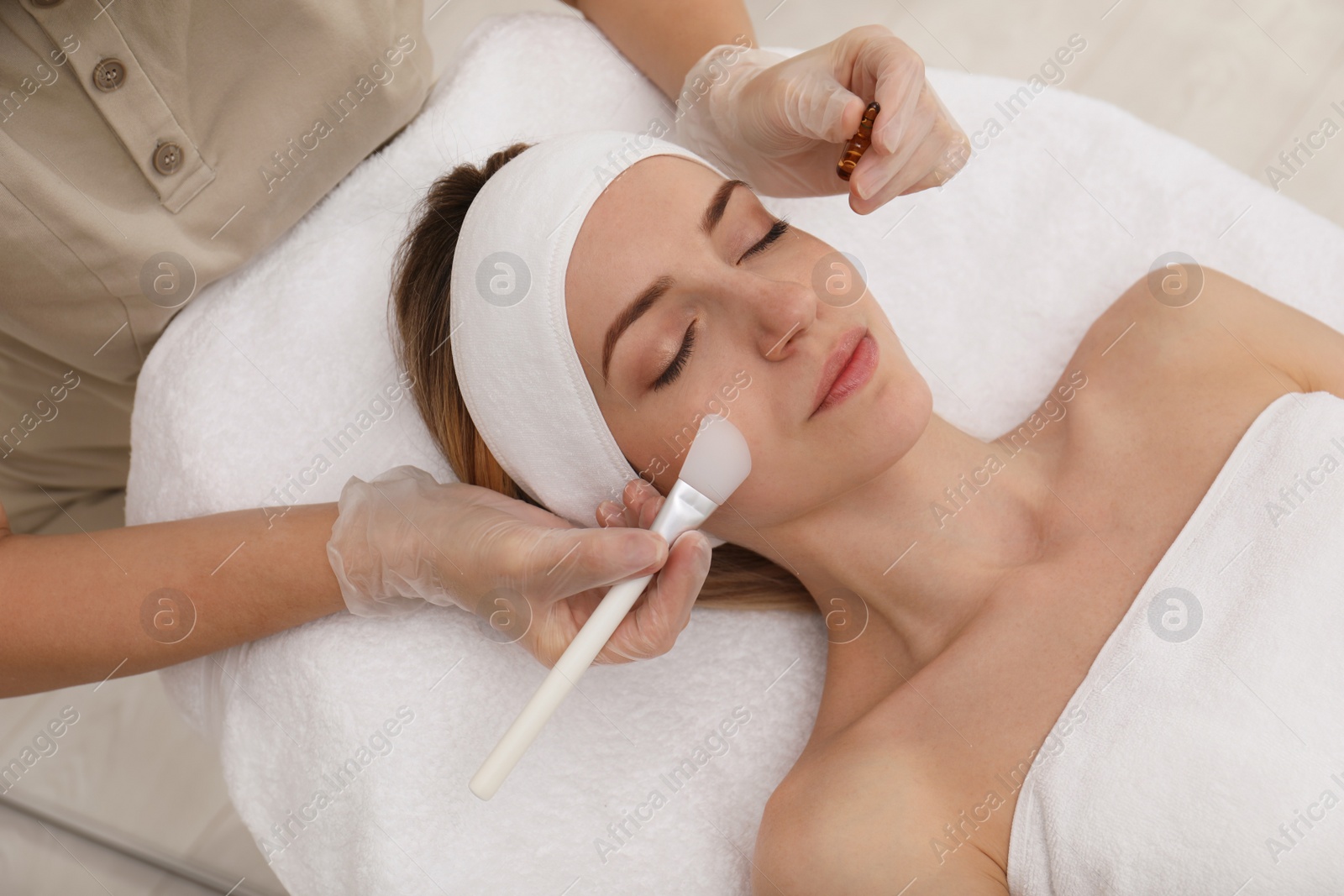 Photo of Young woman during face peeling procedure in salon