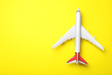 Photo of Top view of toy plane on yellow background, space for text. Logistics and wholesale concept