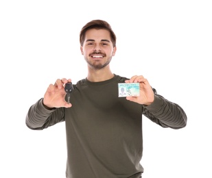 Happy young man with driving license and car key on white background