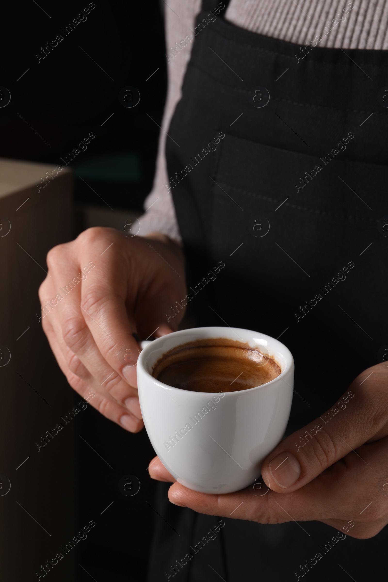 Photo of Woman holding cup of fresh aromatic espresso, closeup