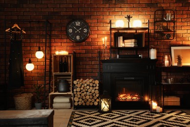 Photo of Stylish living room with beautiful fireplace and different decor at night. Interior design