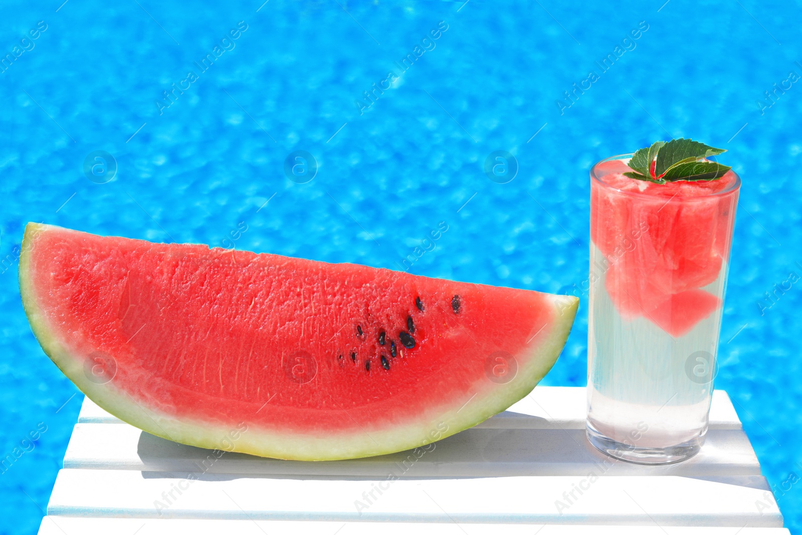 Photo of Refreshing drink in glass and sliced watermelon near swimming pool outdoors. Space for text