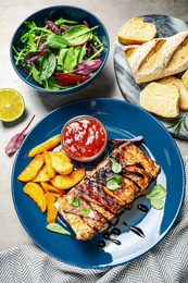 Photo of Delicious grilled ribs served on light grey table, above view