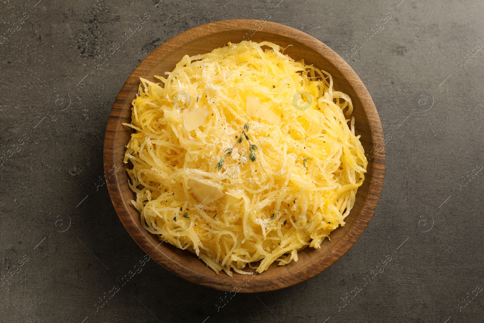Photo of Bowl with cooked spaghetti squash on gray table, top view