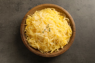 Bowl with cooked spaghetti squash on gray table, top view