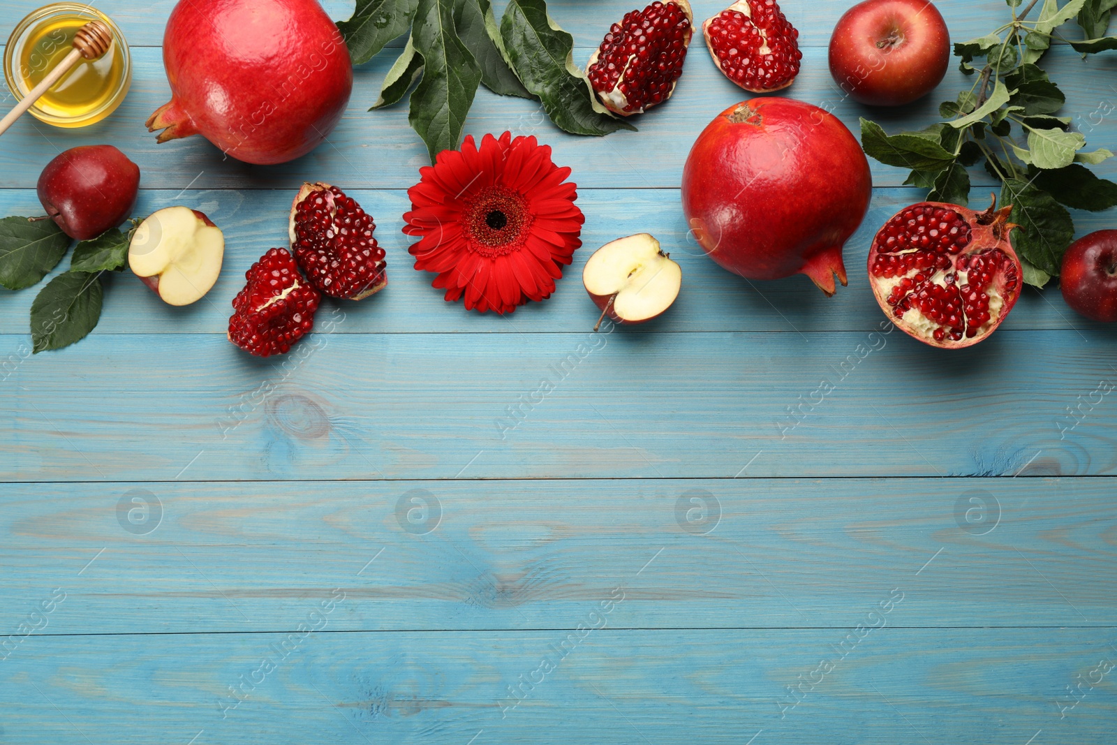 Photo of Flat lay composition with Rosh Hashanah holiday attributes on light blue wooden table. Space for text