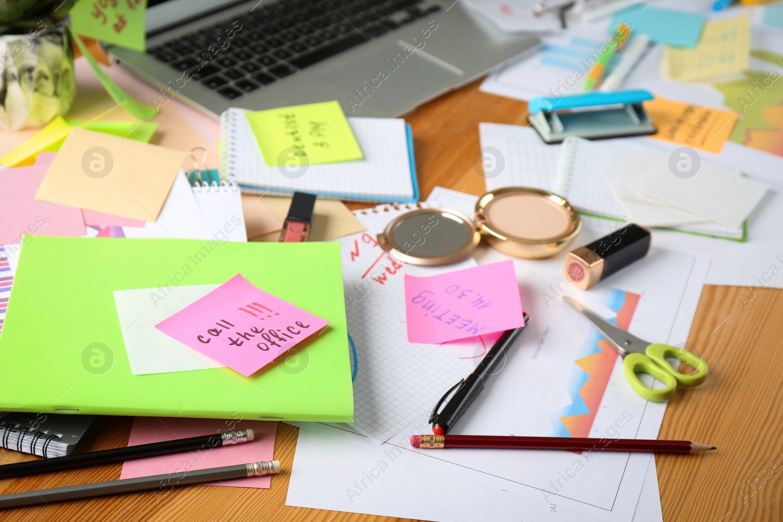 Photo of Messy table with laptop and cosmetics. Concept of being overwhelmed by work