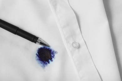 Photo of Pen and stain of blue ink on white shirt, top view. Space for text