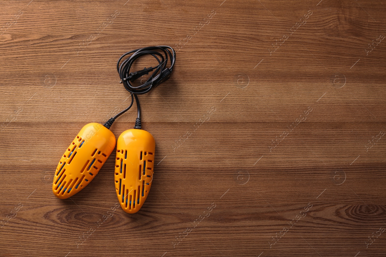 Photo of Electric shoe dryer on wooden background, top view. Space for text