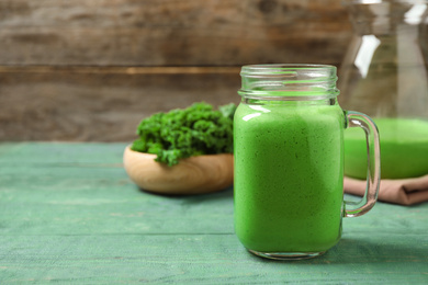 Tasty fresh kale smoothie on light blue wooden table. Space for text