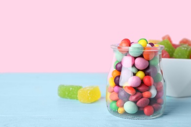 Photo of Yummy candies on light blue table, space for text