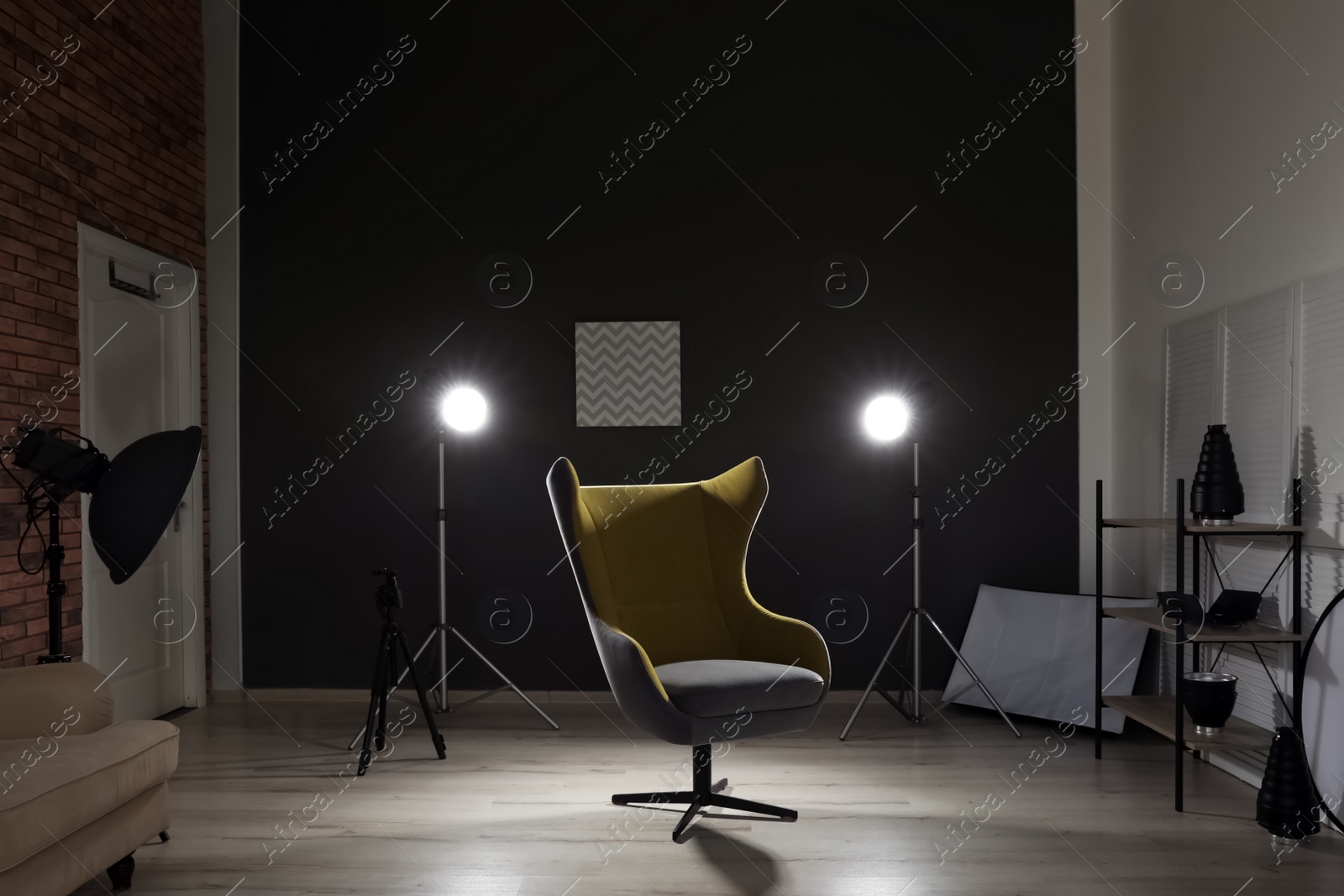 Photo of Interior of modern photo studio with armchair and professional equipment